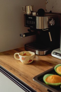 Boynuzlu kahve makinesinin yanında bir fincan kahve.