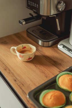 Boynuzlu kahve makinesinin yanında bir fincan kahve.