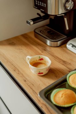 Boynuzlu kahve makinesinin yanında bir fincan kahve.