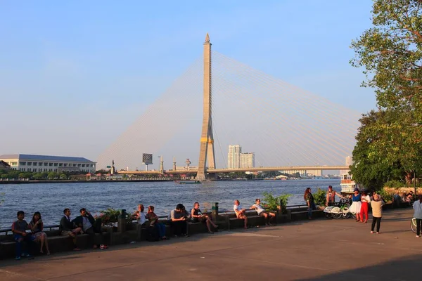 2013年12月21日 人们在曼谷的拉玛九桥的背景下参观了朝弗拉亚河岸 曼谷是泰国最大的城市 有1400万人口居住在城市地区 — 图库照片