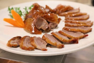 Peking duck. Plate of authentic Chinese cuisine (Beijing cuisine). Sliced duck meat.