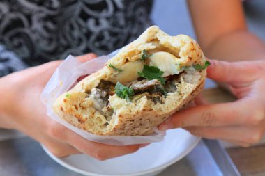 Israeli cuisine. Sabich sandwich (also known as sabih): pita bread filled with eggplants, hard boiled eggs, amba sauce and salad.