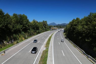 Motorway (Autobahn) in Salzburg state in Austria. Banked turn with concrete surface. clipart