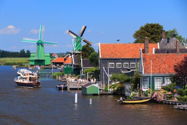 ZAANSE SCHANS, NETHERLANDS - 9 Temmuz 2017 'de insanlar Zaanse Schans' ı ziyaret ederek Hollanda 'daki köyü restore ettiler. Popüler turizm merkezi 2014 yılında 1,6 milyon ziyaretçiye sahipti..