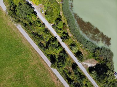Drava Nehri bisiklet yolu (Drauradweg, sağda) Avusturya 'da St. Jakob im Rosental yakınlarında araba yolunun (solda) yanında. İnsansız hava aracından yaz görünümü.
