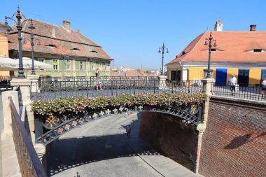 SIBIU, ROMANIA - 24 AĞUSTOS 2012: İnsanlar Romanya 'nın Sibiu kentindeki Yalanlar Köprüsü' nü ziyaret ediyor. Sibiu, Transilvanya 'nın önde gelen turizm merkezlerinden biri..