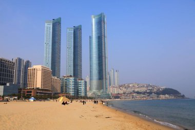 BUSAN, Güney Kore - 29 Mart 2023: Haeundae plajı ile Haeundae LCT The Sharp modern şehir gelişimi Busan, Güney Kore 'nin Haeundae bölgesinde.