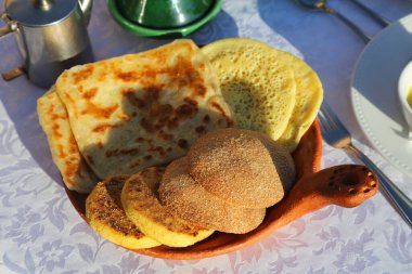 Geleneksel baghrir irmik krepli Fas oteli kahvaltısı, harcha irmikli ekmek ve kavunlu krep. Fas yemekleri.