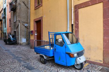 BOSA, ITALY - 28 Mayıs 2023: Sardunya 'daki Bosa kasabasında park halindeki İtalya için tipik tuhaf Piaggio üç tekerlekli mini kamyonlar.