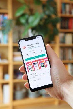 WARsaw, POLAND - 29 Ocak 2021: Android OS, Xiaomi markalı akıllı telefona Sympatia online flört uygulaması yükleyen kullanıcı.