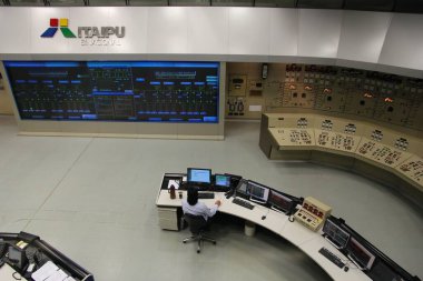 ITAIPU, BRAZIL - OCTOBER 11, 2014: Staff works at Itaipu Binacional Power Plant control room. The famous hydro power plant is located on Paraguay-Brazil border and is shared between two countries. clipart