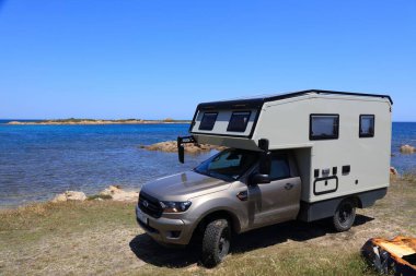 SARDINIA, İtalya - 27 Mayıs 2023: Sardinya 'daki Capo Comino' da park etmiş Ford Ranger kamyonetinden yapılmış off-road 4x4 karavan.