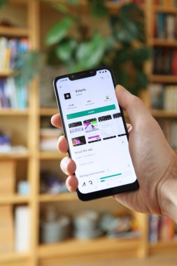 WARsaw, POLAND - 29 Ocak 2021: Android OS, Xiaomi markalı akıllı telefona Volaris havayolu resmi seyahat uygulaması yükleyen kullanıcı.