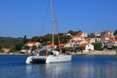 KORCULA, CROATIA - 15 Temmuz 2021: Lagün 410 katamaran Korcula Adası 'ndaki Lumbarda Marina' dan ayrılıyor. Hırvatistan, Avrupa 'da ünlü bir yaz yelkencilik beldesi.