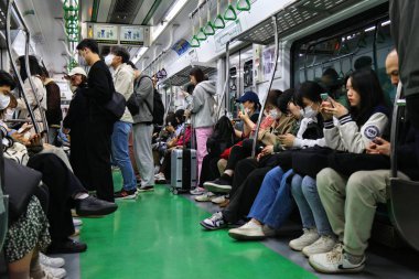 SEOUL, Güney Kore - 7 Nisan 2023: Seul 'de bir metroya binen yolcular. Seul metro sistemi dünyanın en büyük metro şebekelerinden biridir..