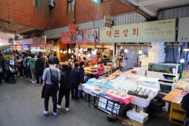 SEOUL, Güney Kore - 7 Nisan 2023: İnsanlar Güney Kore 'nin Jongno bölgesindeki Gwangjang Market' in balık ve kimchi yemek bölümünü ziyaret ediyor.