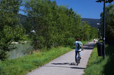 SALZBURG, AUSTRIA - 4 Ağustos 2023: Bisikletçiler Salzburg, Avusturya yakınlarındaki Tauern-Radweg uzun mesafe bisiklet rotasına biniyorlar.