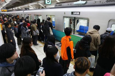 TOKYO, JAPONYA - 3 Aralık 2016: Tokyo 'daki Ikebukuro İstasyonu' nda yerel banliyö trenine binmek için kuyrukta bekleyenler.