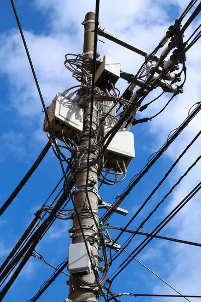 Electric grid in Japan. Concrete electric pole with wires.