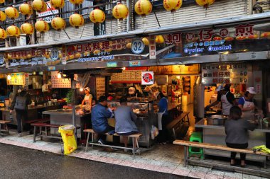 Keelung, Tayvan - 23 Kasım 2018: İnsanlar Tayvan 'ın Keelung kentindeki ünlü Miaokou Gece Pazarı' nı ziyaret ediyor. Gece pazarları Tayvan gıda kültürünün önemli bir parçasıdır..