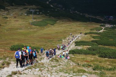 TATRA dağları, POLAND - 9 Eylül 2023: Polonya 'daki Tatrzanski Park Narodowy (Tatra Milli Parkı)' ndaki Dolina Gasienicowa vadisinde turistler sarı patikada yürüyüş yapıyor.