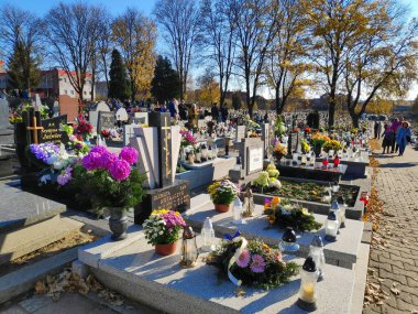 BYTOM, POLAND - 1 Kasım 2021: Polonya 'da Azizler Günü' nde (Wszystkich Swietych) bir mezarlığı ziyaret edenler.