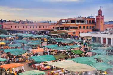 MARRAKESH, MOROCCO - 20 Şubat 2022: İnsanlar Marakeş şehrinin kare pazarı Jemaa el-Fnaa 'yı (Djemaa el Fna) ziyaret ediyor. Meydan, UNESCO İnsanlığın Soyut Mirasının Başyapıtı olarak listelendi.