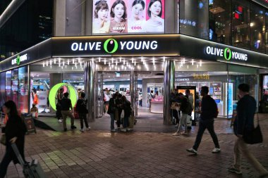 SEOUL, Güney Kore - 5 Nisan 2023: İnsanlar geceleri Myeongdong 'daki Olive Young Koreli güzellik dükkanını ziyaret ediyor..