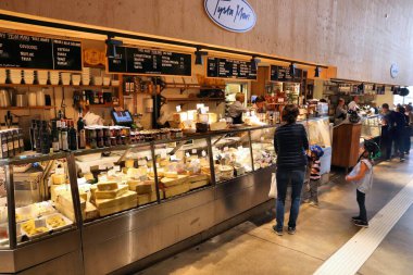 STOCKHOLM, SWEDEN - 24 Ağustos 2018: İnsanlar Stockholm 'deki Ostermalm' s Market Saluhall 'daki peynir dükkanını ziyaret ediyor. Et, balık ve gurme gıdalara odaklı bir gıda pazarıdır..