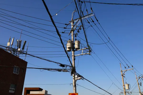 Electric grid in South Korea. Concrete utility poles in Busan city. Step down transformers.