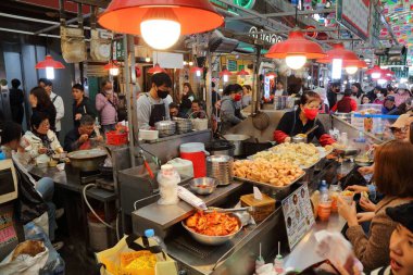 SEOUL, Güney Kore - 7 Nisan 2023: İnsanlar Güney Kore 'nin Jongno bölgesindeki Gwangjang Market' te mandu Kore mantısı yiyorlar.