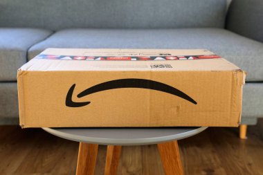 WARA, POLAND - 18 ARALIK 2023: Amazon çevrimiçi market sipariş kutusu paketi Noel 'den önce, tatil tasarım kasetiyle birlikte Avrupa' ya teslim edildi.