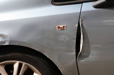 Generic car with scratched paint and dented parts on the side. Minor accident result - fender bender.