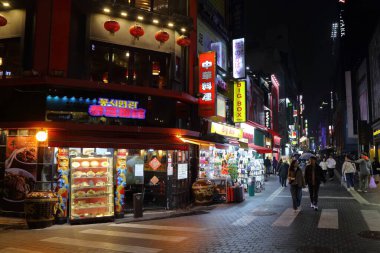 SEOUL, Güney Kore - 5 Nisan 2023: İnsanlar yağmurlu bir gecede Seul 'deki Myeongdong alışveriş bölgesini ziyaret ediyor.