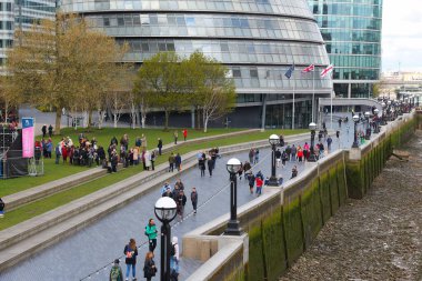 LONDON, İngiltere - 23 Nisan 2016: Southwark Londra 'daki South Bank Embankment' ta insanlar Queen 's Walk boyunca yürüyor.