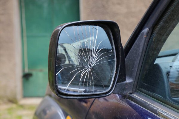 Broken side mirror of a generic car in Italy. Car damage.