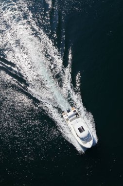 Motorlu tekne Norveç fiyordunda hava görüntüsünü uyandırıyor. Yaz denizi güneşli hava.