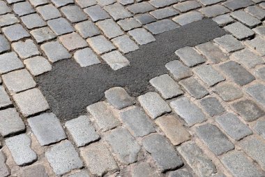 Almanya, Nuremberg 'de taş kaldırımda hasar görmüş. Çağdaş çözeltiyle tamir edilen kaldırım taşı: asfalt yüzey.