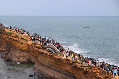 YEHLIU, TAIWAN - NOVEMBER 24, 2018: People visit Yehliu Geopark in Taiwan. Yehliu is a popular tourism destination with peculiar natural rock forms clipart
