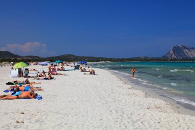 SARDINIA, İtalya - 26 Mayıs 2023: İnsanlar Sardinya, İtalya 'da güneşli bir günde San Teodoro' daki La Cinta 'nın kumlu plajını ziyaret ediyor.