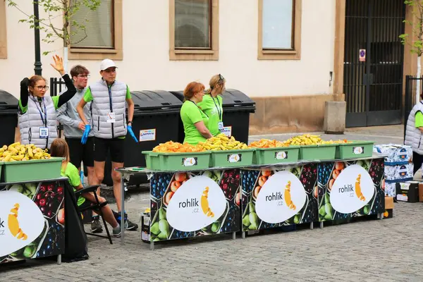 stock image PRAGUE, CZECH REPUBLIC - MAY 5, 2024: Volunteers give out fruit snacks for runners in Prague Marathon, one of biggest marathon races in Europe.