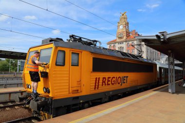 PRAG, CZECH REPUBLIC - 1 Mayıs 2024: Çek Cumhuriyeti Prag İstasyonu 'ndaki (Praha Hlavni Nadrazi) Regiojet yolcu treninin ön camını temizleyen işçi. Regiojet özel düşük maliyetli bir tren operatörü..