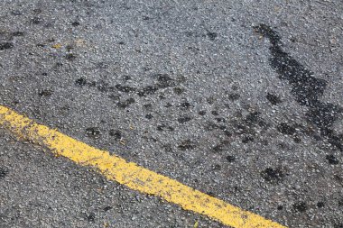 Malezya 'da park yeri yağ lekeleri. Toprak kirliliği sorunu. Asfalt yüzeyinde yağ lekeleri.