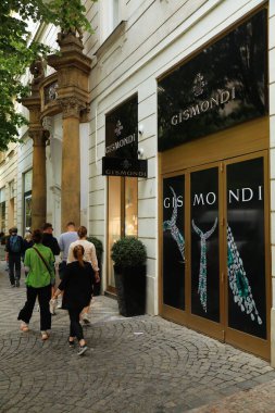 PRAG, CZECH REPUBLIC - 2 Mayıs 2024: İnsanlar Prag, Çek Cumhuriyeti 'nde üst düzey moda alışverişleriyle tanınan Parizska caddesindeki Gismondi lüks mücevher mağazasının önünden geçtiler.