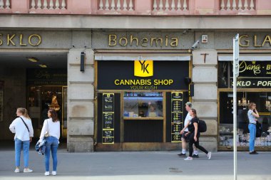 PRAG, CZECH Cumhuriyet - 1 Mayıs 2024: İnsanlar Prag, Çek Cumhuriyeti 'nde bir esrar dükkanının önünden geçiyor.