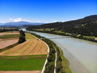 Drava River bicycle path (Drauradweg, on the right) alongside car road (left) near St. Jakob im Rosental, Austria. Summer view from a drone. clipart