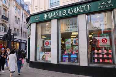Londra, İngiltere - 14 Temmuz 2019: Londra 'da insanlar Hollanda ve Barrett mağazasının önünden geçiyor. Holland ve Barrett doğal bir ilaç ve sağlıklı besin deposu zinciri..