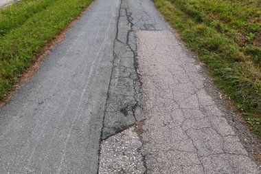 Avusturya, Carinthia 'da kırsal yol yüzeyinde hasar var. Kırsal yol bakımı kavramı.