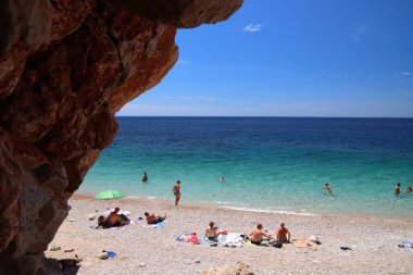 KONAVLE, CROATIA - 28 Haziran 2019: İnsanlar Hırvatistan 'ın Dalmaçya bölgesindeki Konavle bölgesindeki kayalıkların altındaki Pasjaca plajında tatil yapıyorlar.