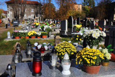 Polonya 'da Azizler Günü' nde (Wszystkich Swietych) bir mezarlıkta süslenmiş mezarlar ve kasımpatı çiçekleri.